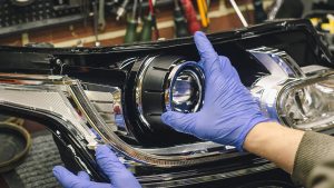 Car,Headlight,In,Repair,Close-up.,An,Auto,Mechanic,Wearing,Gloves