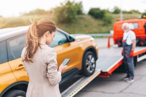 Elegant,Middle,Age,Business,Woman,Calling,Someone,While,Towing,Service